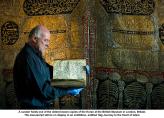 Куратора на изложбата, държи най-старото копие от Корана в света